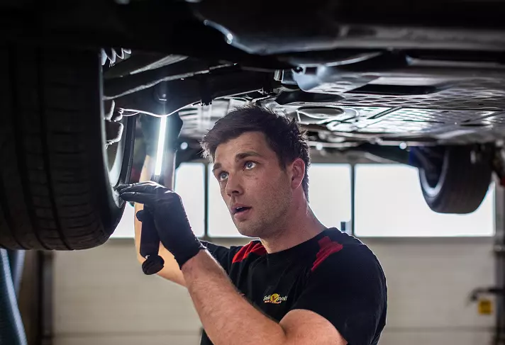Mekaniker som utfører en kontroll på bilens understell